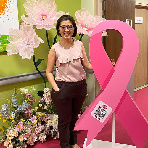 Dr-Christina-Lai taking photo with the breast cancer pink ribbon
