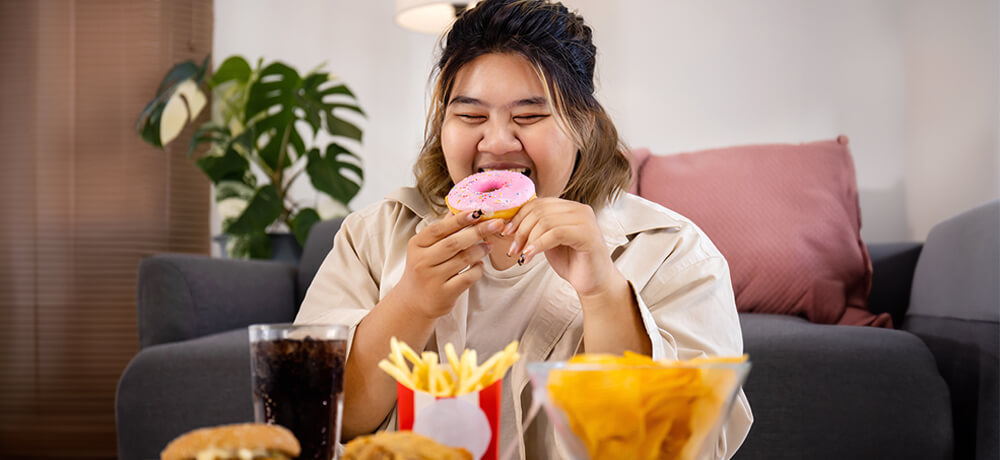 happy-asian-fat-woman-enjoy-eating-delicious-sweet-donut-fast-food-living-room